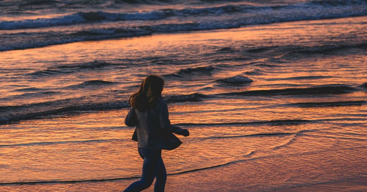 A runner on the beach at sunset